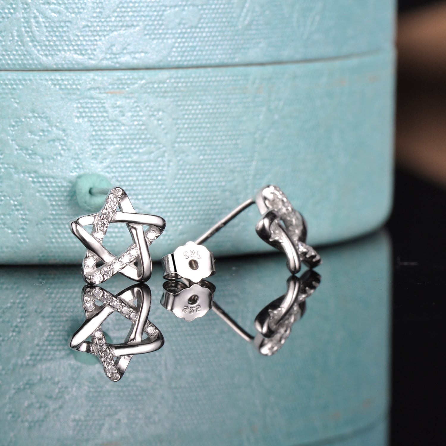Сребърни обеци във формата на звезда с много камъни циркони по тях